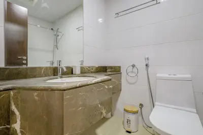 a bathroom with a marble sink and a toilet at Apartment in Downtown As Dormitory Room for female in Dubai