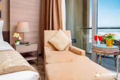 a hotel room with a bed and a chair and a window at Emmar fashion avenue Dubai mall in Dubai