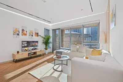 a living room with a white couch and a tv at Luxury 1BR Suite I Boulevard View I Downtown Dubai in Dubai
