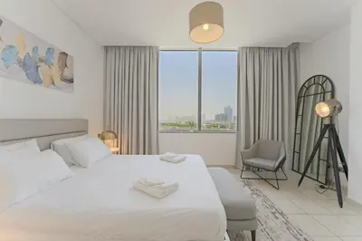 a bedroom with a bed and a chair and a window at Luxury 2BR Sky Gardens Appartment Downtown DIFC in Dubai