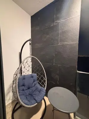 a basket chair and a table in a room at Azizi Riviera 1 A in Dubai