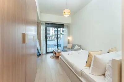 a living room with a white couch in a room at PVH - Cozy Studio in Azizi Riviera 43 in Dubai