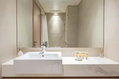 a bathroom with a white sink and a shower at PVH - Cozy Studio in Azizi Riviera 43 in Dubai