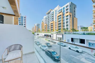 a balcony with a view of a city street with cars at PVH - Cozy Studio in Azizi Riviera 43 in Dubai