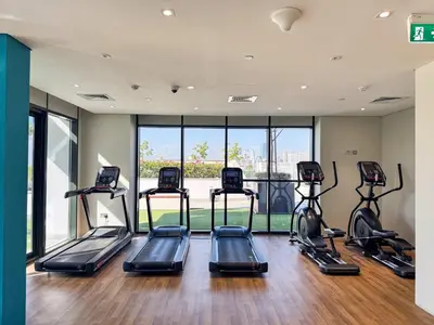 a gym with several treadmills in a room at PVH - Modern Studio Near Downtown - Azizi Riviera in Dubai