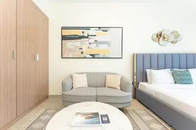 a living room with a bed and a couch and a chair at PVH - Modern Studio Near Downtown - Azizi Riviera in Dubai