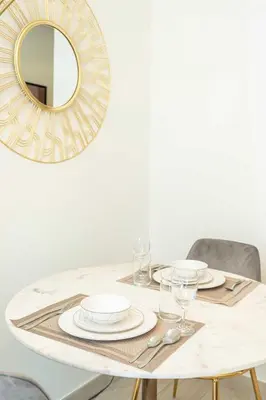 a dining room table with a mirror on the wall at PVH - Modern Studio Near Downtown - Azizi Riviera in Dubai