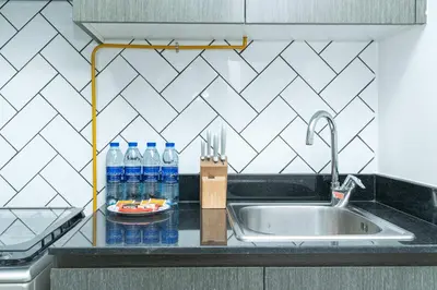 a kitchen counter with bottles of water and a sink at PVH - Homely Studio near Miracle Garden in Dubai