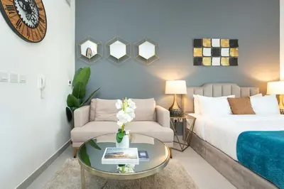 a bedroom with a bed and a couch and a table at PVH - Homely Studio near Miracle Garden in Dubai