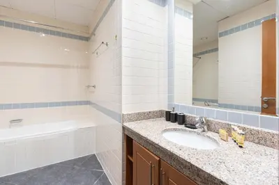 a bathroom with a sink and a tub and a mirror at PVH - Sunny Studio near Metro - Madison Residency in Dubai