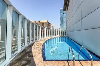 a balcony with a swimming pool on a building at PVH - Sunny Studio near Metro - Madison Residency in Dubai
