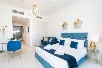 a blue and white bedroom with a bed and a couch at PVH - Classy Studio with Golf Course View - Carson in Dubai