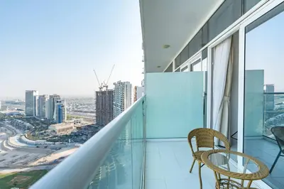 a balcony with two chairs and a view of the city at PVH - Classy Studio with Golf Course View - Carson in Dubai