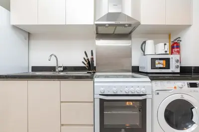 a kitchen with a washing machine and a microwave at PVH - Classy Studio with Golf Course View - Carson in Dubai
