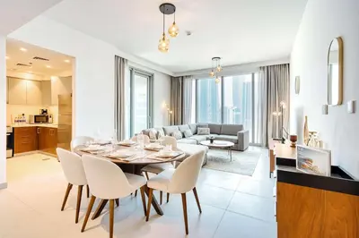 a dining room and living room with a table and chairs at PVH - Forte Tower 1 - Opulent 2BR near Dubai Mall in Dubai