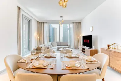 a dining room with a table and chairs in a living room at PVH - Forte Tower 1 - Opulent 2BR near Dubai Mall in Dubai
