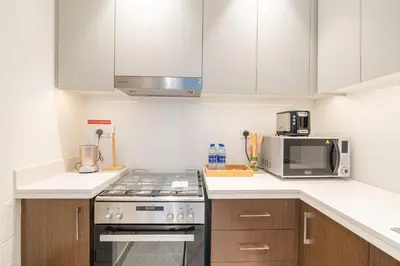 a kitchen with a stove and a microwave at PVH - Forte Tower 1 - Opulent 2BR near Dubai Mall in Dubai
