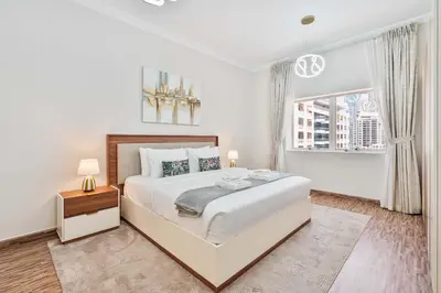 a white bedroom with a large bed and a window at PVH - 2BR near Marina Promenade - Marina Pearl in Dubai