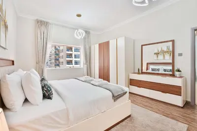 a white bedroom with a large bed and a mirror at PVH - 2BR near Marina Promenade - Marina Pearl in Dubai