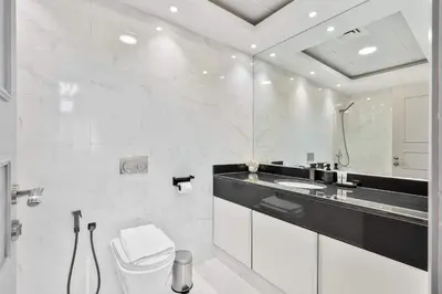 a white bathroom with a toilet and a sink at PVH - 2BR near Marina Promenade - Marina Pearl in Dubai