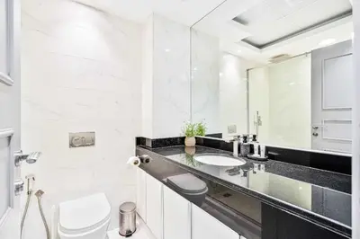 a bathroom with a sink and a toilet and a mirror at PVH - 2BR near Marina Promenade - Marina Pearl in Dubai