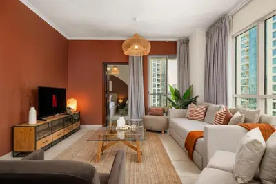 a living room with a couch and a tv at Downtown Gem, 1 BDR Apartment, Walk to Dubai Mall & Burj khalifa in Dubai