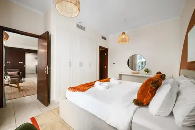 a bedroom with a white bed with a teddy bear on it at Downtown Gem, 1 BDR Apartment, Walk to Dubai Mall & Burj khalifa in Dubai