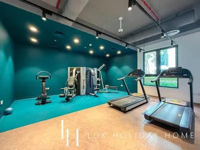 a gym with several tread machines in a room at LUX The Le Pont Sea View Suite in Dubai