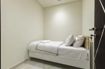 a white room with a bed with white sheets and pillows at Luxury 3Br Apts with Private Pool in Gemz by Simply Comfort in Dubai