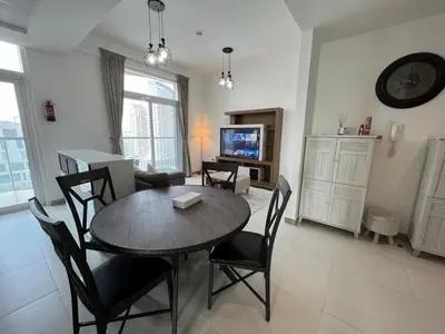 a dining room and living room with a table and chairs at Binghatti Gateway 2BHK At Jaddaf By al Sarya Holiday Home in Dubai
