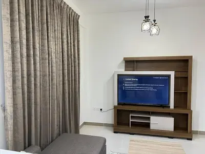 a living room with a tv and a curtain at Binghatti Gateway 2BHK At Jaddaf By al Sarya Holiday Home in Dubai