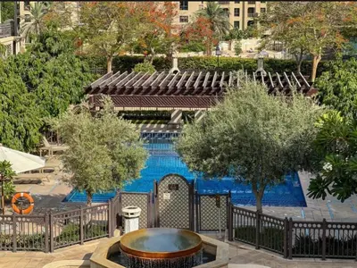 a swimming pool with a fountain in front of a building at Souk Al Bahar connected to Dubai Mall, Burj khalifa Partial View Dream View Holiday Home Rental in Dubai