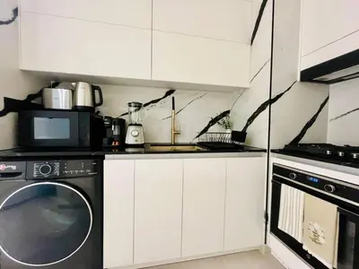 a kitchen with a washing machine and a microwave at Business Bay Studio Jacuzzi & Iconic View in Dubai