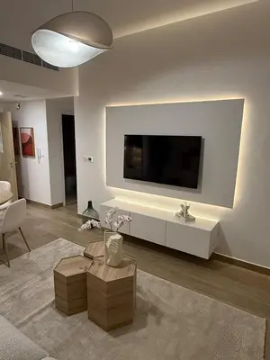 a living room with a flat screen tv on a wall at Appartement moderne et élégant in Dubai