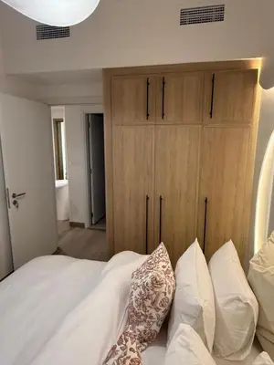 a bedroom with a bed with white sheets and pillows at Appartement moderne et élégant in Dubai