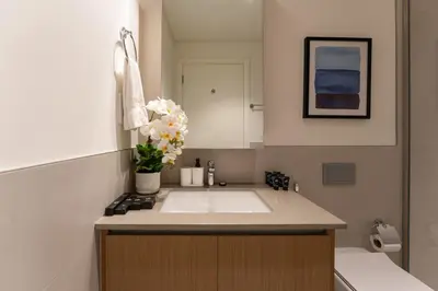 a bathroom with a sink and a vase of flowers at Maison Privee - Serene Hideaway with Top Facilities in Creek Beach in Dubai
