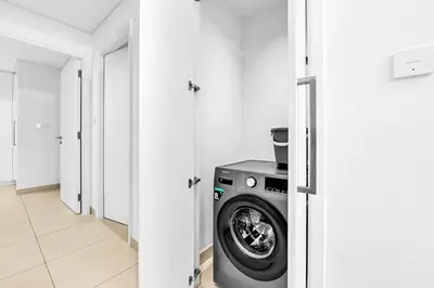 a washer and dryer in a white laundry room at Modern 2BR at Burj Crown Walk to Burj Khalifa by Vibel Stay in Dubai