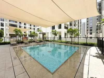 a large swimming pool in a building with an umbrella at Chic Dubai Apartment Creek View Peaceful Vibes in Dubai