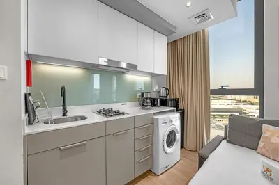 a kitchen with a sink and a washing machine at Peaceful Studio Midtown 20 mins to Expo City by Vibel in Dubai