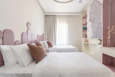 two beds in a room with white and pink at Luxury Villa with Pool and Garden 4BR The Springs in Dubai
