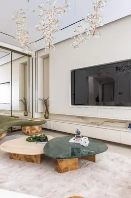 a living room with two tables and a large tv at Luxury Villa with Pool and Garden 4BR The Springs in Dubai