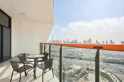 a balcony with a table and chairs and a view of a city at One Bedroom Apartment in Binghatti Avenue by The S Holiday Homes in Dubai