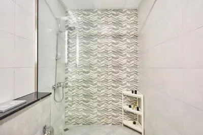 a shower with a glass door in a bathroom at One Bedroom Apartment in Binghatti Avenue by The S Holiday Homes in Dubai