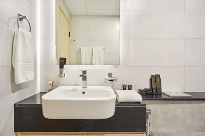 a bathroom with a white sink and a mirror at One Bedroom Apartment in Binghatti Avenue by The S Holiday Homes in Dubai