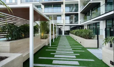 an internal courtyard of a building with grass and plants at Cozy 1br In Jvc Pool, Balcony & Free Parking in Dubai