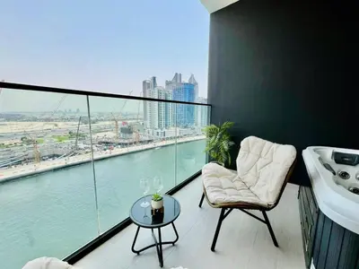 a bathroom with a tub and a sink and a table at Canal-view Studio Jacuzzi Business Bay in Dubai