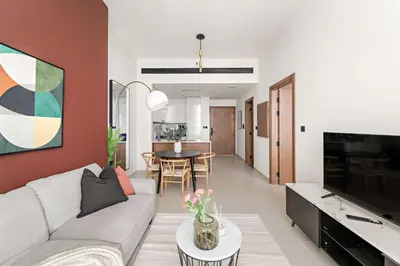 a living room with a couch and a tv and a table at Silkhaus New 1BDR Retreat at Binghatti Tulip in JVC in Dubai