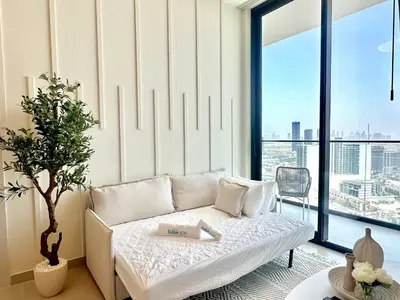 a living room with a white couch and a large window at Elegant 1 Bedroom in Binghatti Tulip - JVC in Dubai