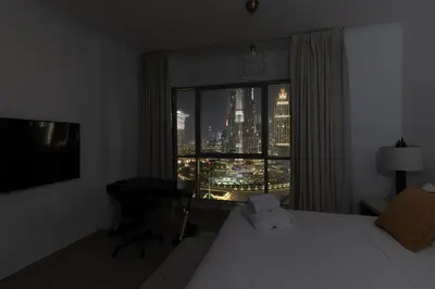 a bedroom with a window with a view of a city at Burj and Fountain view 3BR plus maids room in Dubai