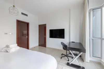 a bedroom with a bed and a desk and a television at Burj and Fountain view 3BR plus maids room in Dubai